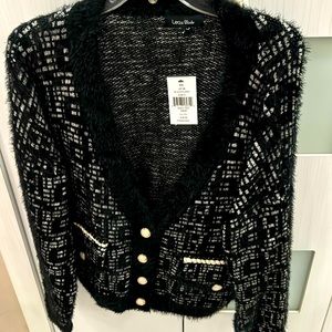 Black and white sweater with tags and pearl buttons.